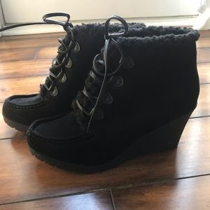 Lace-up black booties with fur trim.
